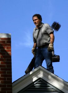 Man performing chimney sweep - cost discussing article